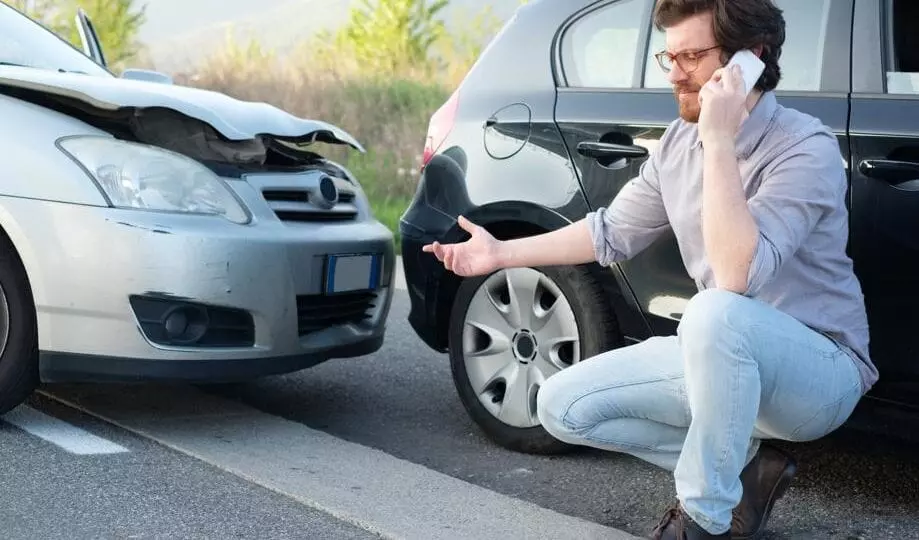Man on phone dealing with fender bender