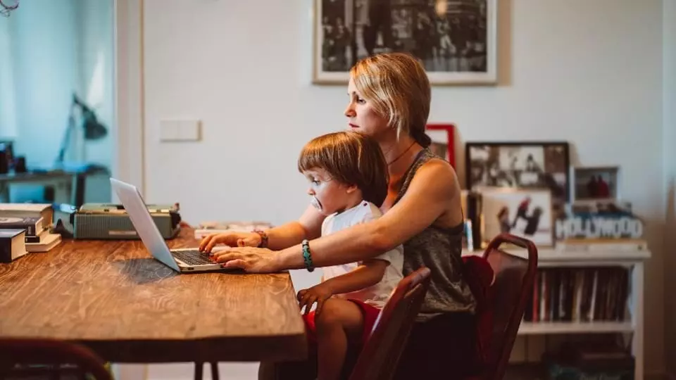 Working from home with her young child on her lap