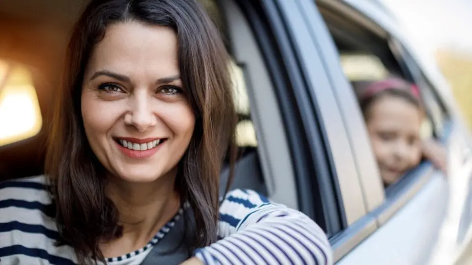 mother drive a car with child in the back seat