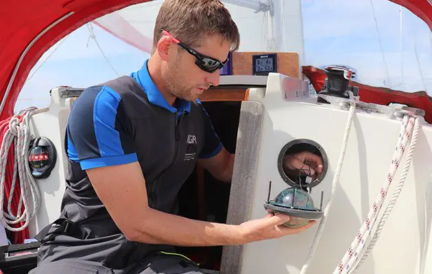 man maintaining his boat with a new light
