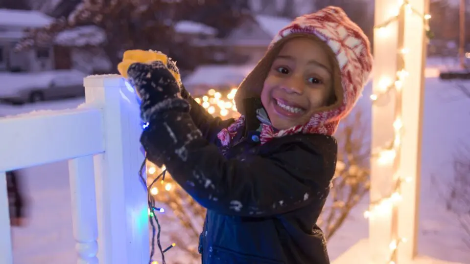 young boy helping to decorate his home for the Holidays.