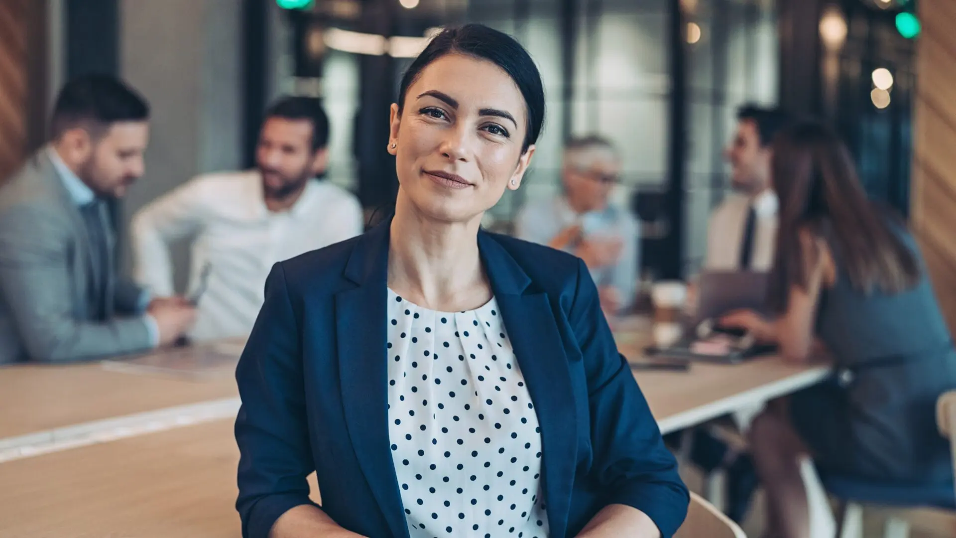 Lawyer in meeting room with her team in the background