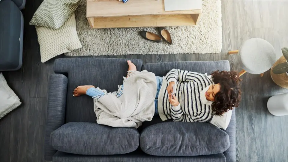 female in on her sofa texting a friend