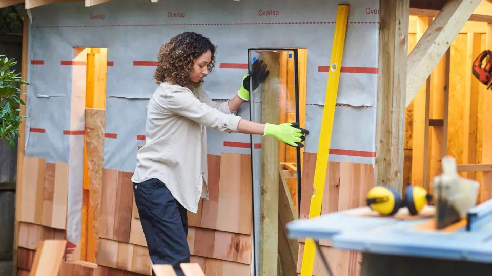 a woman building a backyard shed