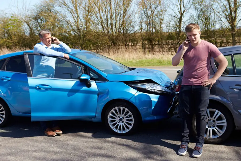 two men on thier phones after a car accident