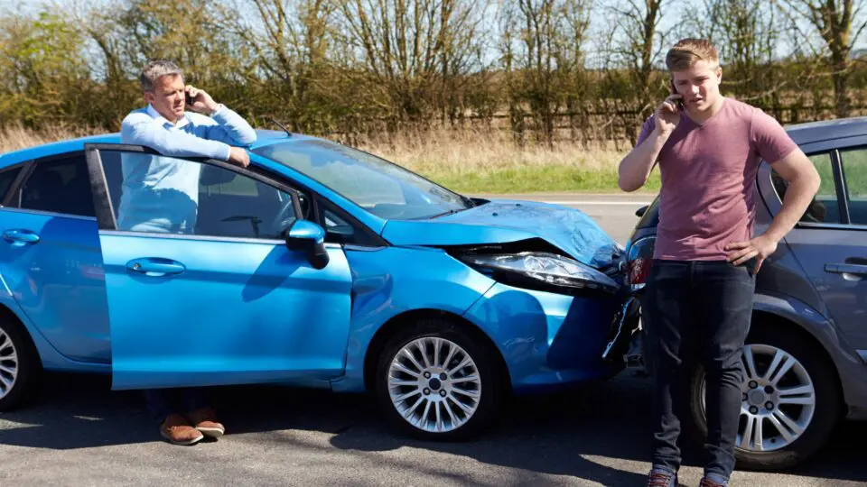 two men on thier phones after a car accident
