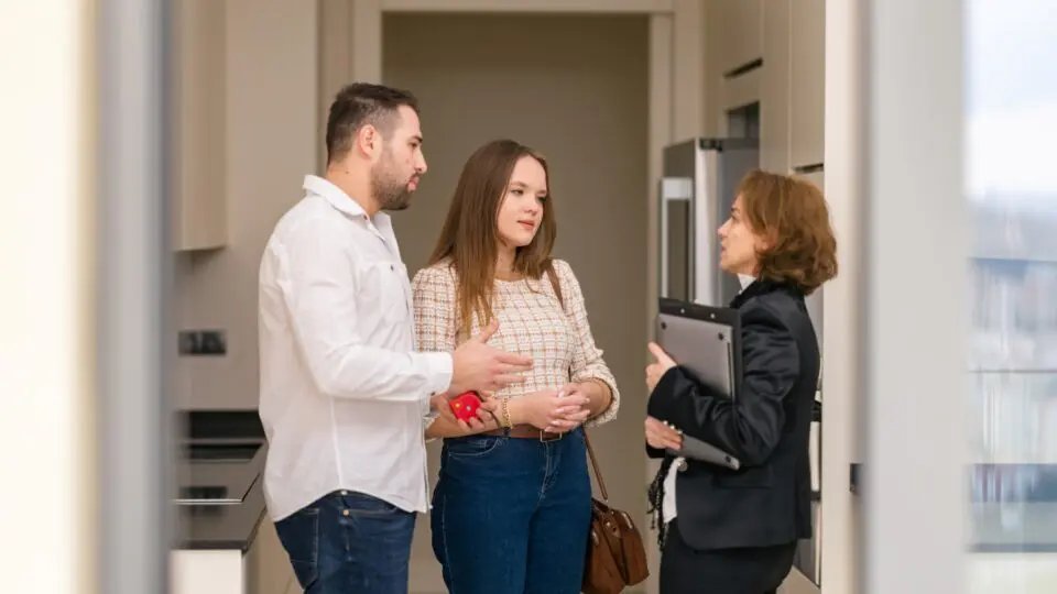 A couple talking with an advisor at a home