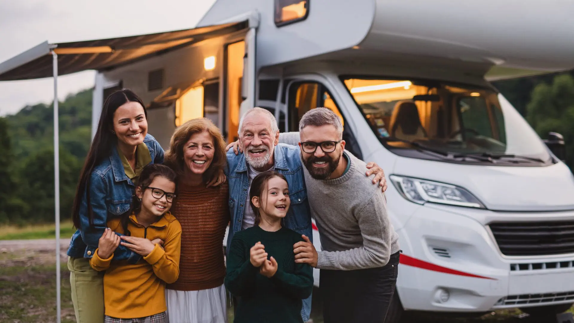 a family gathering for a photo in front of their RV