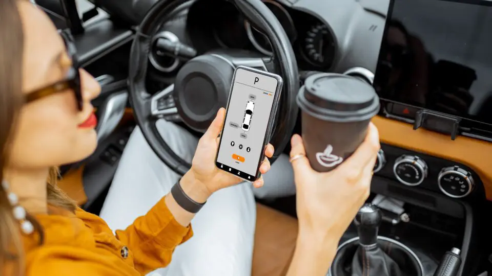 a driver using her vehicle assistance system to park