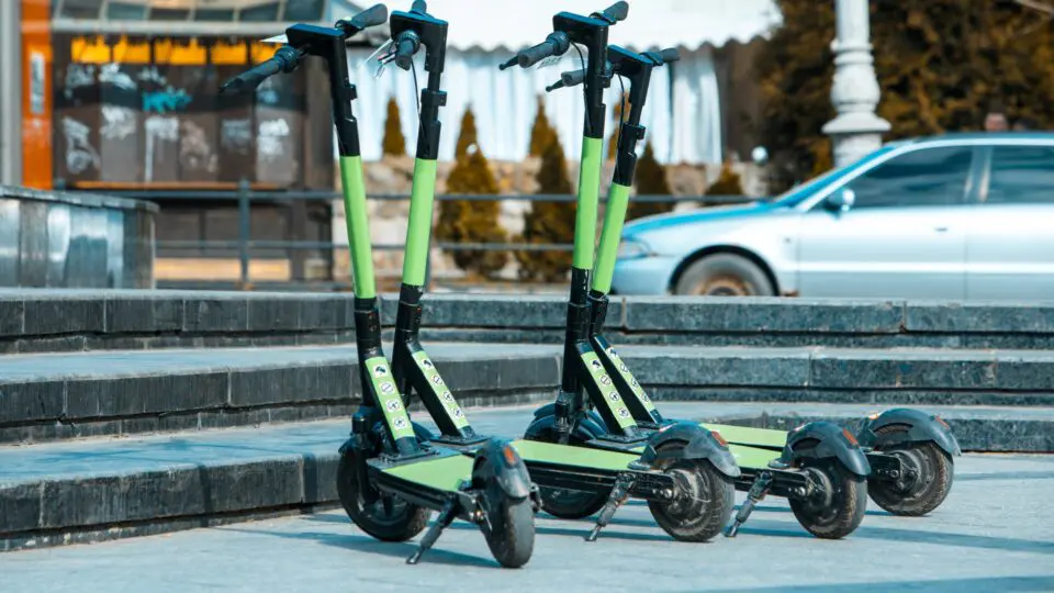 a collection of e-scooters parked on a city