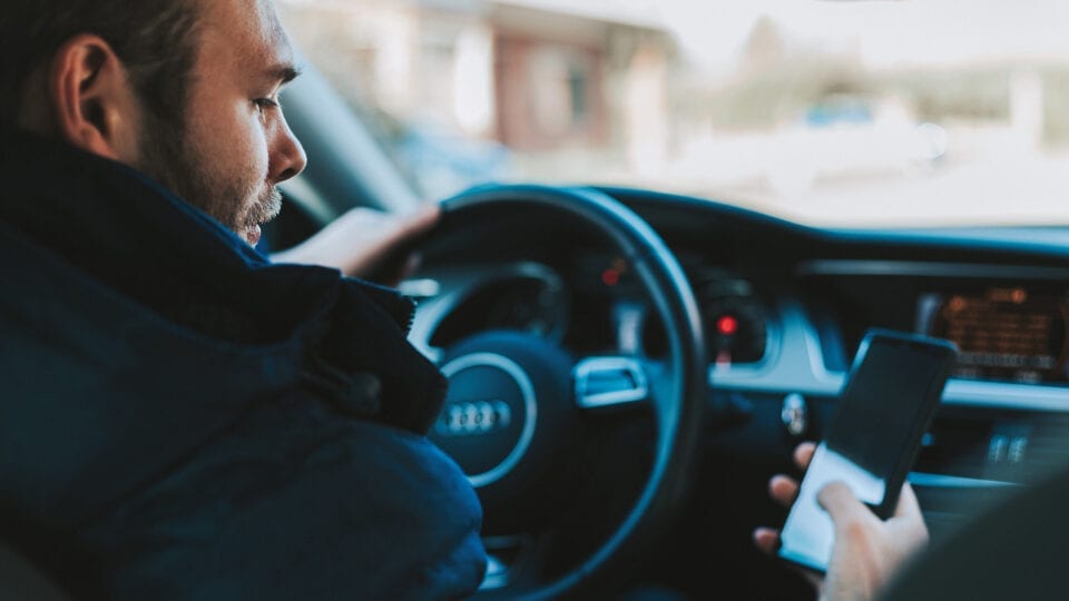 Man looking at his phone while driving