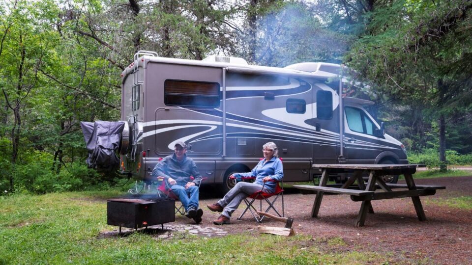 Nova Scotia couple sitting in front of their RV camping.