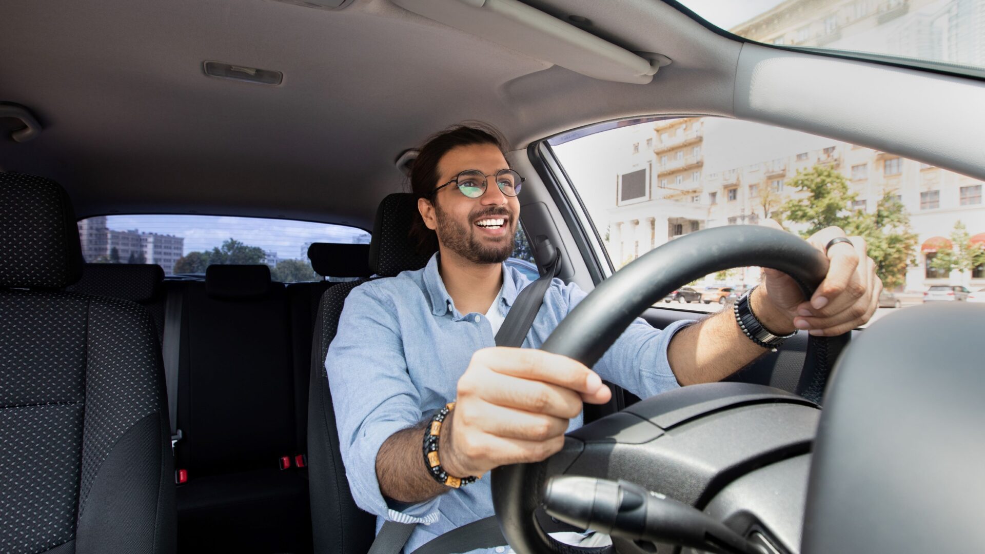 Man in a car driving with two hands on the wheel