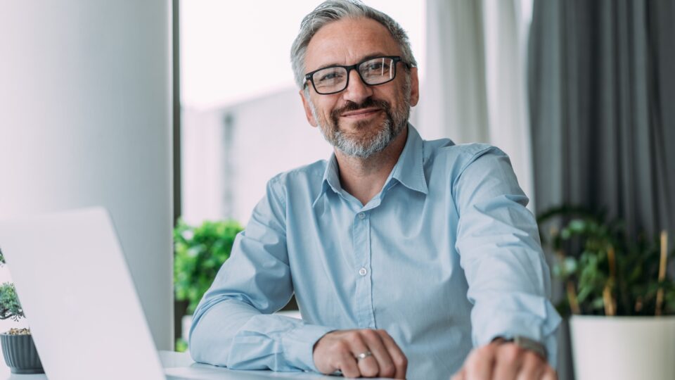 A small business owner posing for a photo at his desk