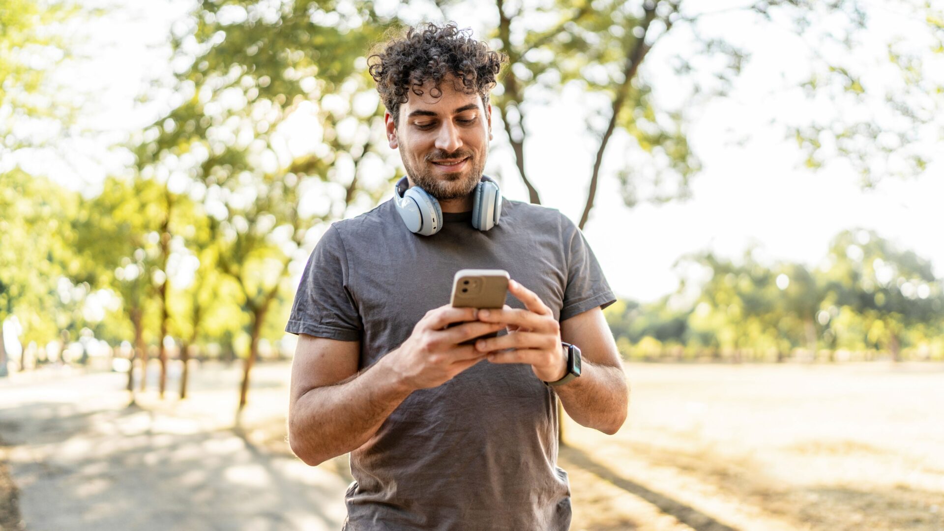 Man on looking at his smartphone in a park
