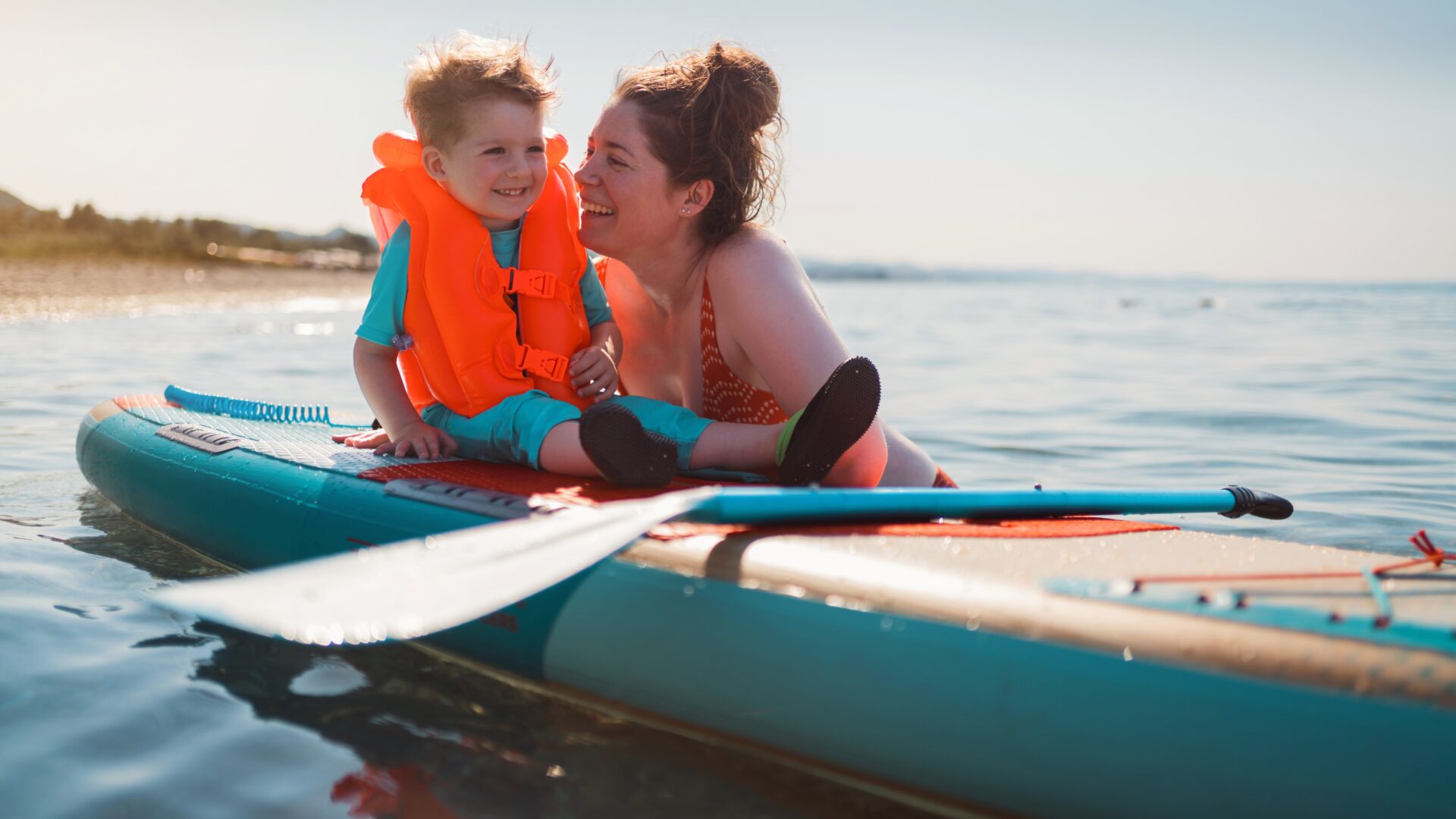 Mother with her son on a paddle board